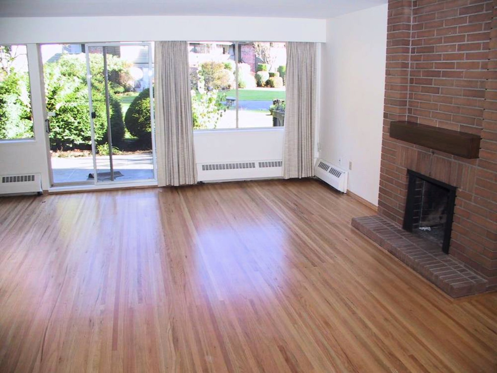 Living Room Re-finished hardwood floors, wood burning brick fireplace, level walk-out tiled patio overlooking parklike grounds.