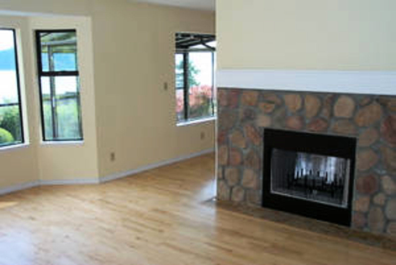 Living Room Birchwood floors with wood burning fireplace and ocean view.